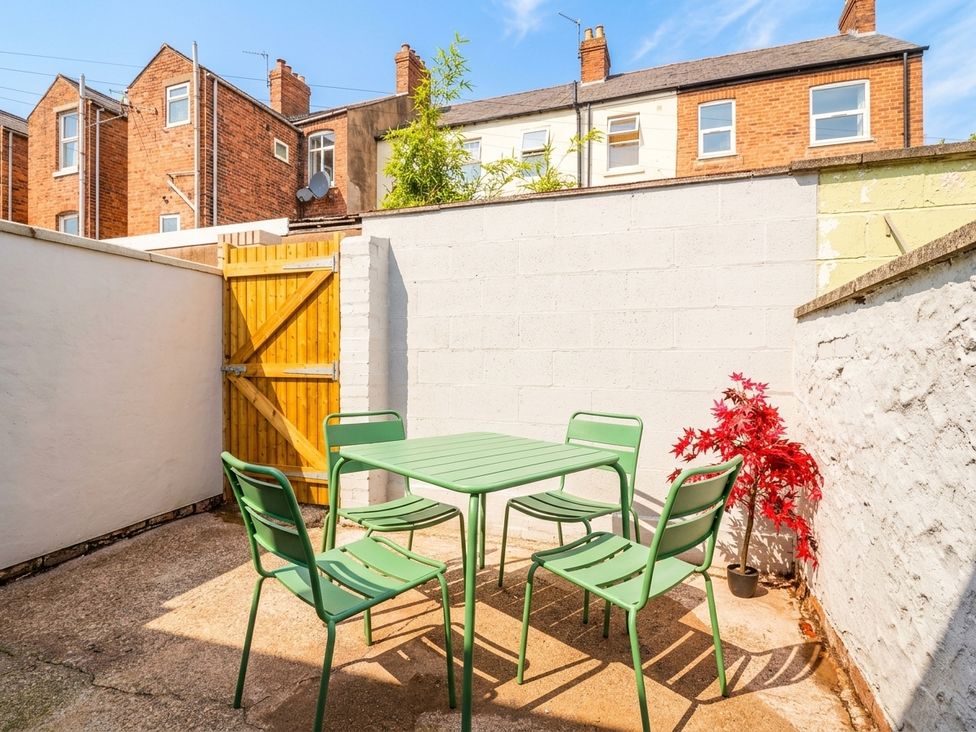 A garden with a green table and chairs at 9 North Street in Chester