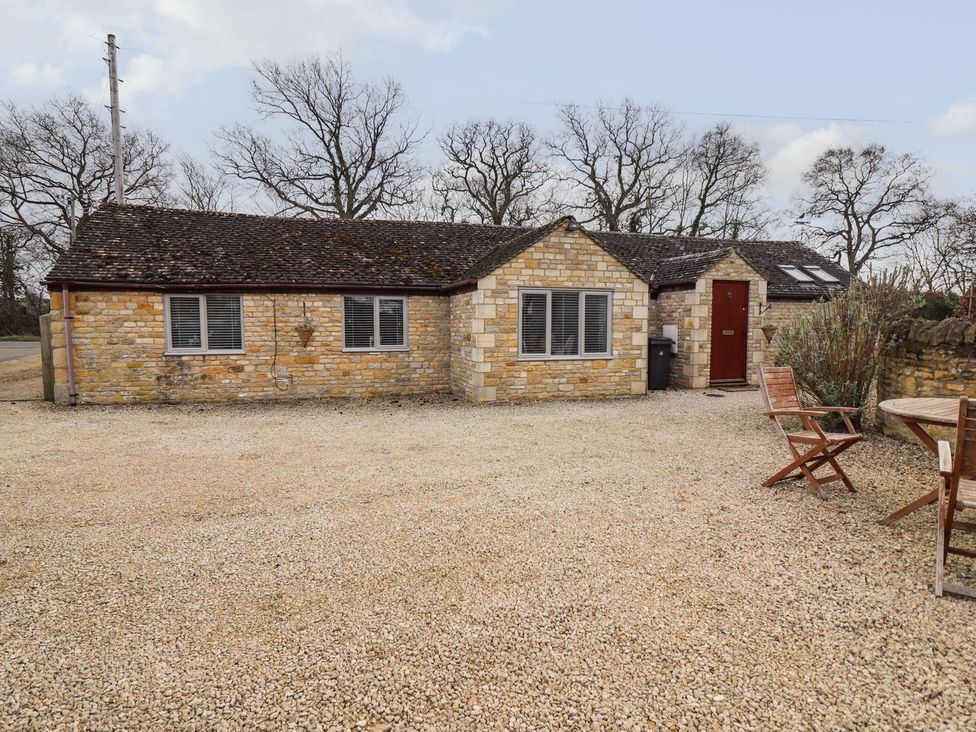 A house with gravel driveway and garden furniture at Peewit Barn in Moreton-in-Marsh