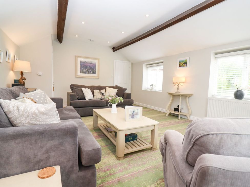 A living room with sofas and a coffee table at Peewit Barn in Moreton-in-Marsh