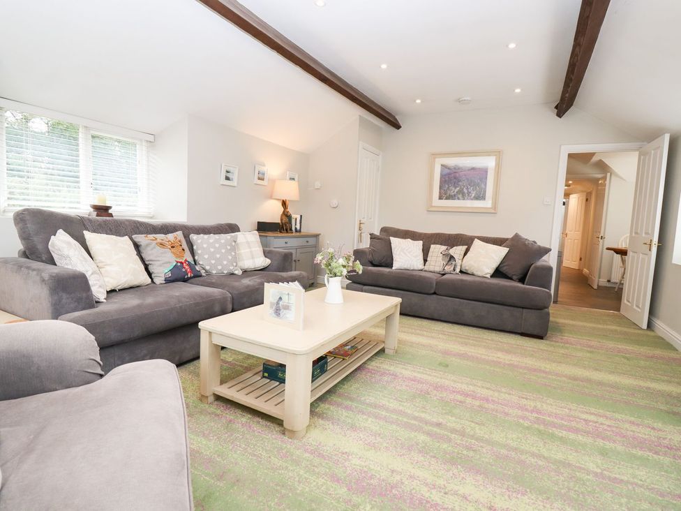 A living room with sofas and a coffee table at Peewit Barn Moreton-in-Marsh