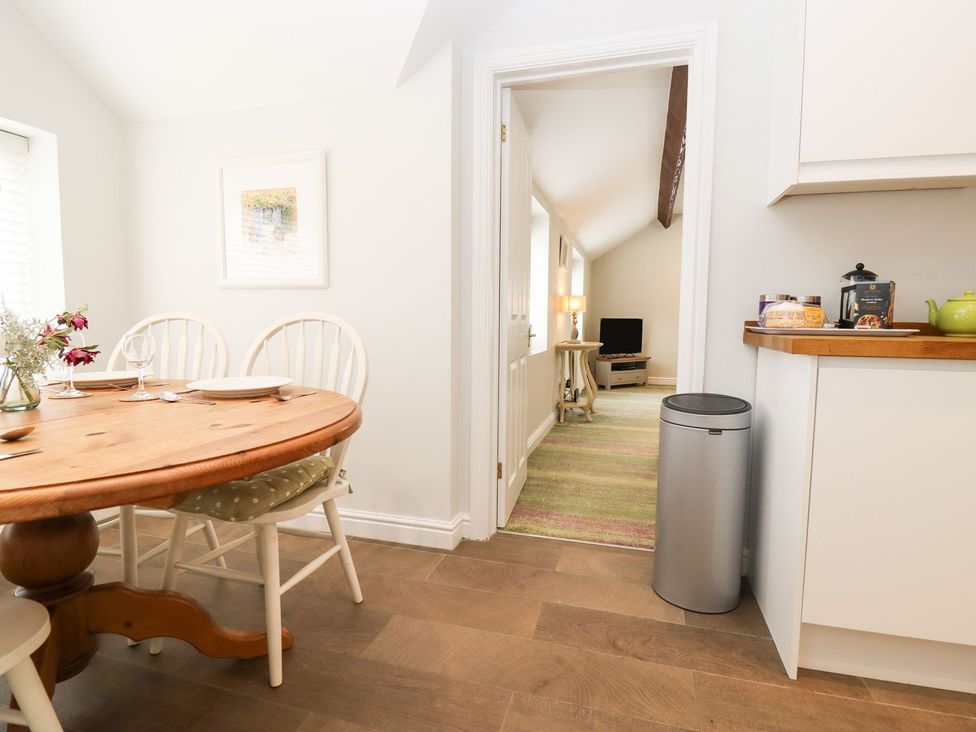 A dining room with a wooden table and chairs at Peewit Barn in Moreton-in-Marsh
