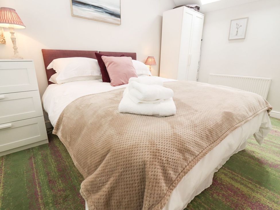 A bedroom with a bed and bedside lamp at Peewit Barn in Moreton-in-Marsh