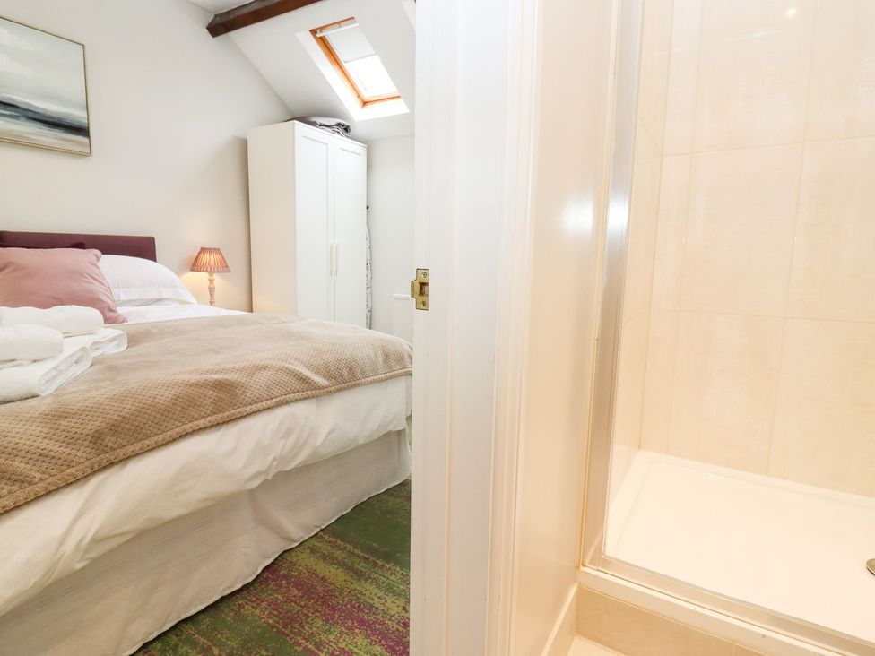 A bedroom with a bed and a shower at Peewit Barn Moreton-in-Marsh