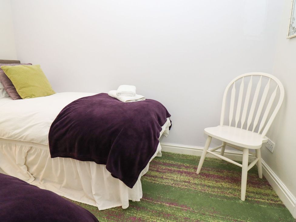 A bedroom with a bed and a chair at Peewit Barn in Moreton-in-Marsh