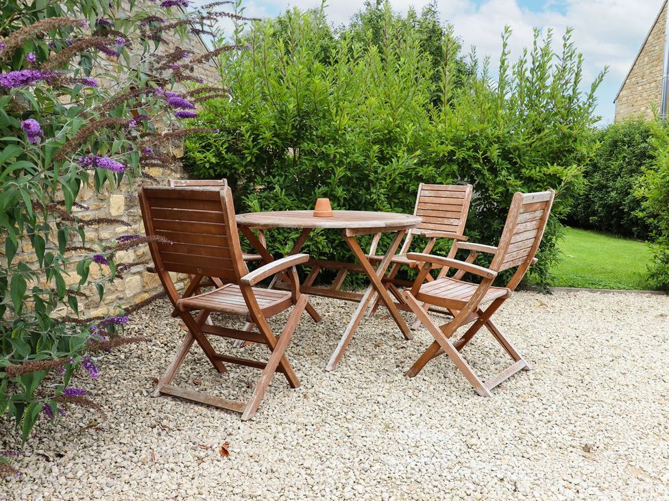 A table and three chairs in a garden at Peewit Barn in Moreton-in-Marsh