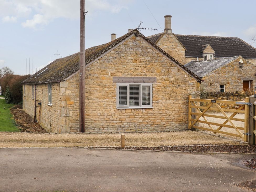 A stone building with a window and gate at Peewit Barn in Moreton-in-Marsh