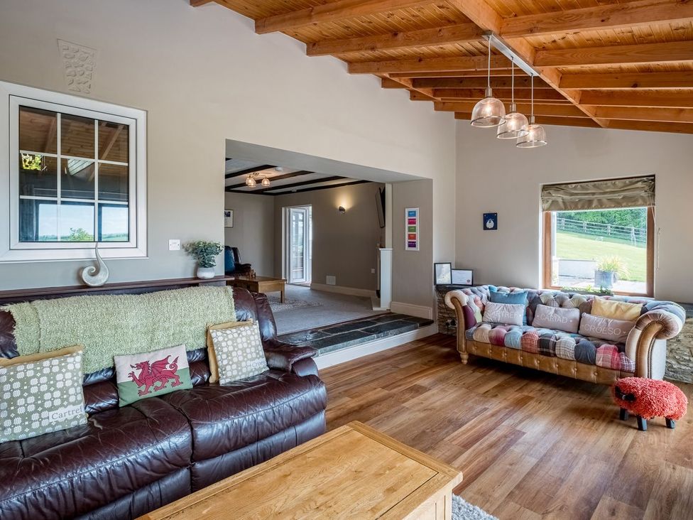 A living room with two sofas and a wooden table at Blaenachddu in Newcastle Emlyn