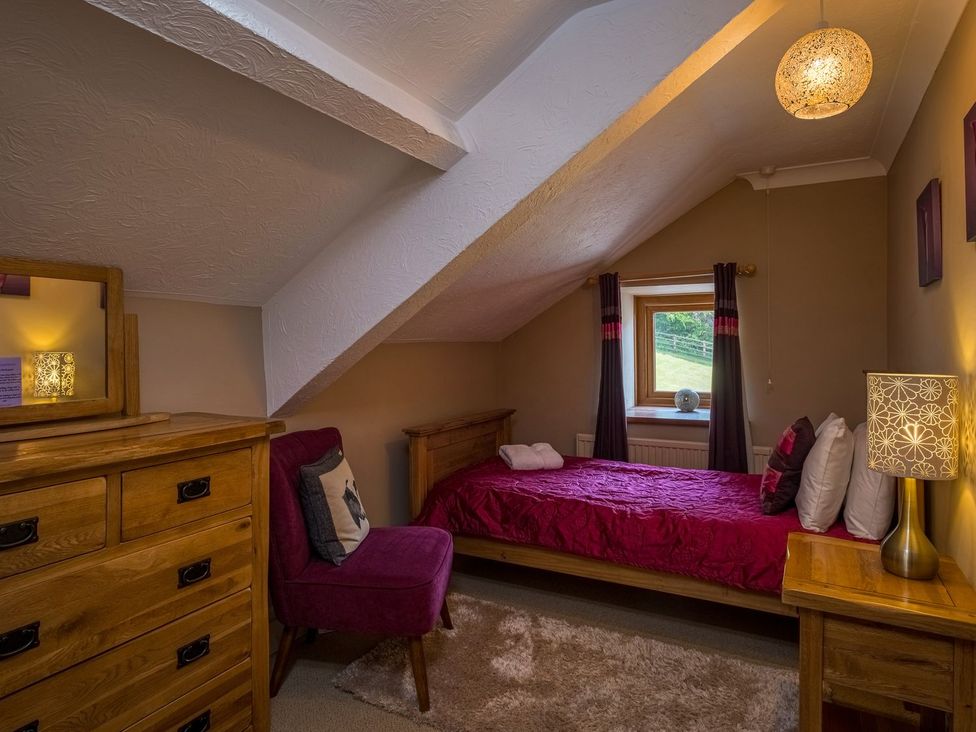 A bedroom with a bed and furniture at Blaenachddu in Newcastle Emlyn