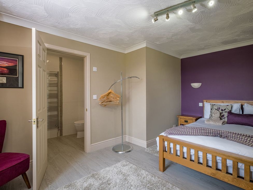 A bedroom with a bed and a chair at Blaenachddu Newcastle Emlyn