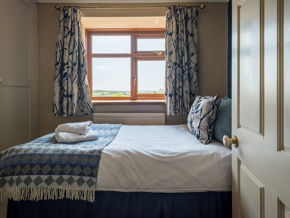 A bedroom with a bed and window at Blaenachddu in Newcastle Emlyn
