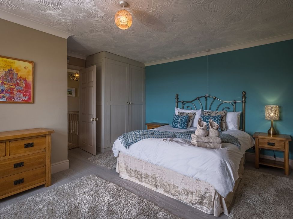 A bedroom with a bed and wardrobe at Blaenachddu in Newcastle Emlyn