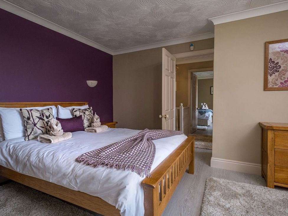 A bedroom with a bed and dresser at Blaenachddu in Newcastle Emlyn