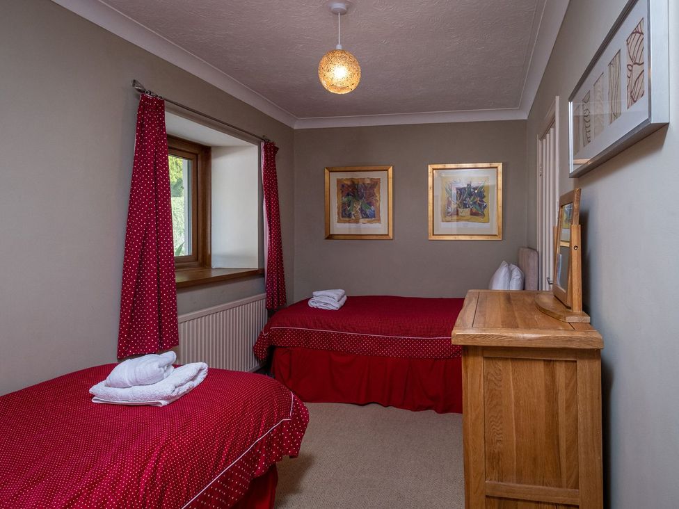A bedroom with two beds and a dresser at Blaenachddu in Newcastle Emlyn