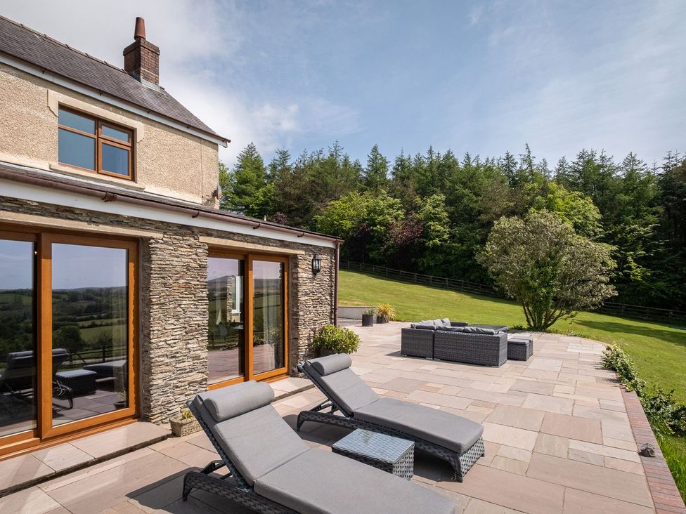 An outdoor patio area with chairs and a table at Blaenachddu Newcastle Emlyn