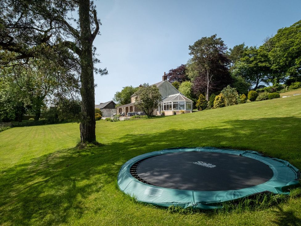 An outdoor view with a trampoline and house at Blaenachddu Newcastle Emlyn