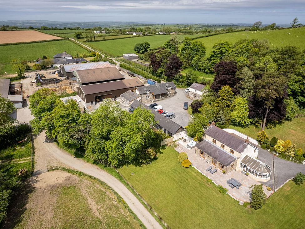 An outdoor view of a farmhouse and surrounding structures at Blaenachddu Newcastle Emlyn