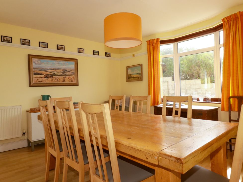 A dining area with a wooden table and chairs at Chy-an-Lowena in Crantock