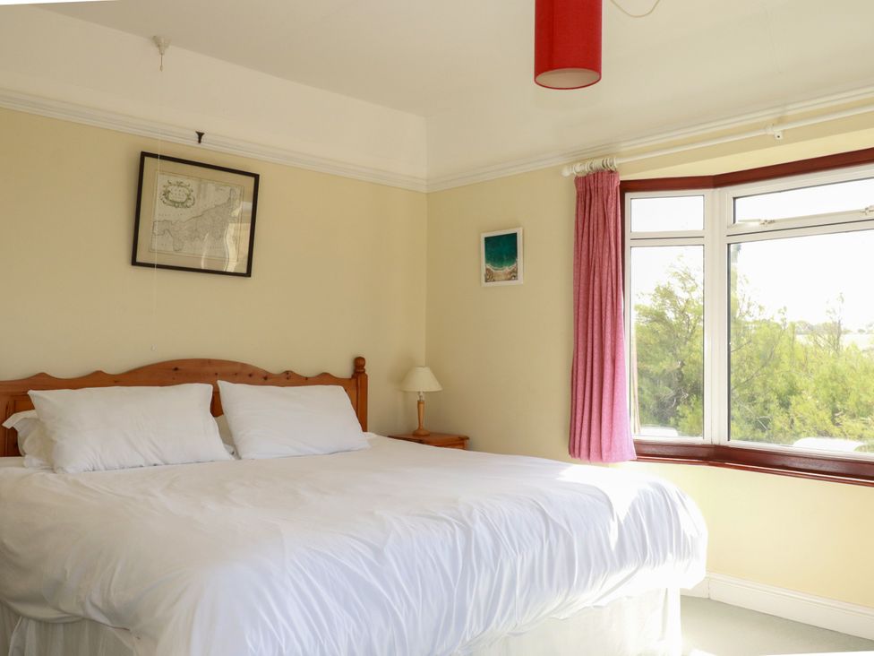 A bedroom with a bed and window at Chy-an-Lowena in Crantock