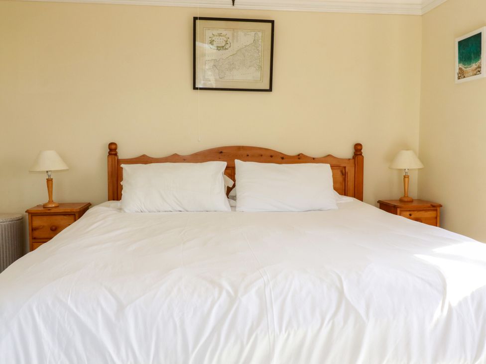 A bedroom with a bed and bedside tables at Chy-an-Lowena in Crantock