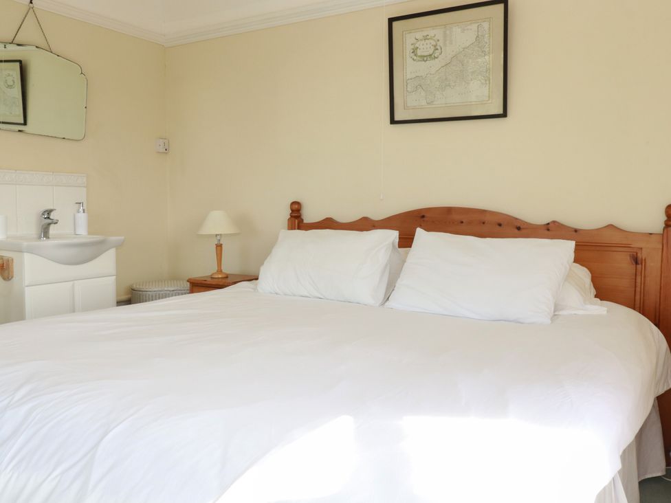 A bedroom with a bed and a mirror at Chy-an-Lowena Crantock