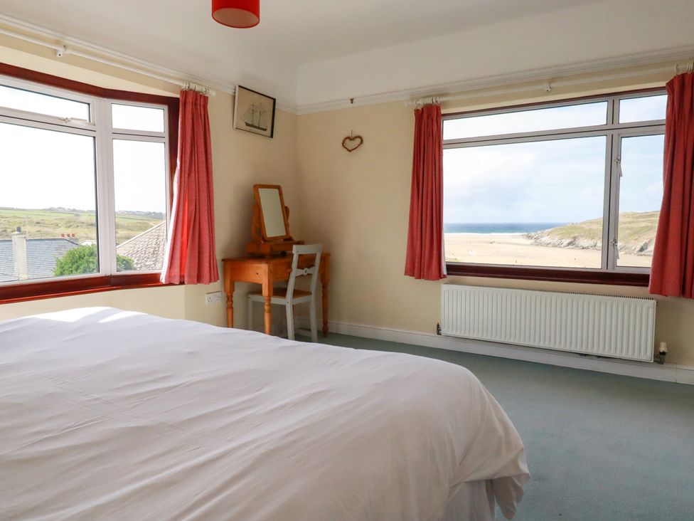A bedroom with a bed and a dressing table at Chy-an-Lowena in Crantock
