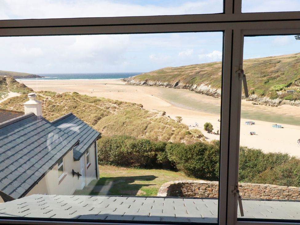 A view of a beach and ocean from a window at Chy-an-Lowena in Crantock