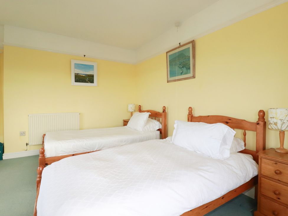 A bedroom with two beds and a nightstand at Chy-an-Lowena in Crantock