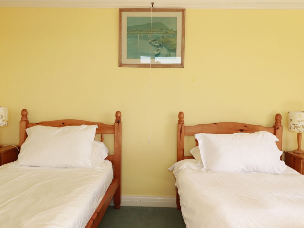 A bedroom with two beds and a picture at Chy-an-Lowena in Crantock