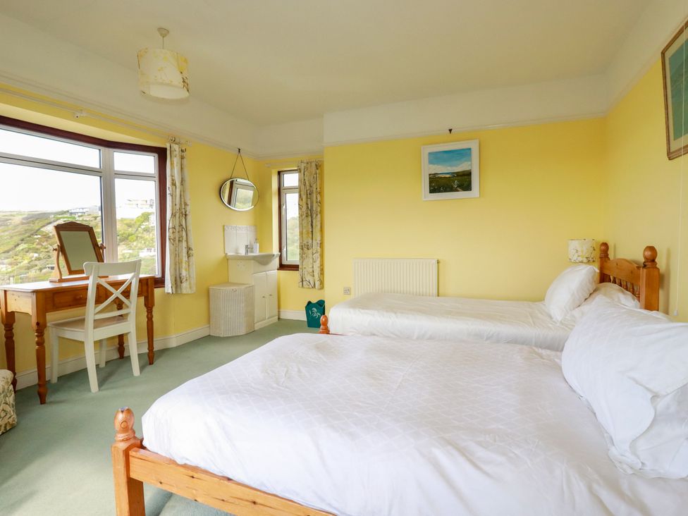 A bedroom with two beds and a vanity at Chy-an-Lowena in Crantock