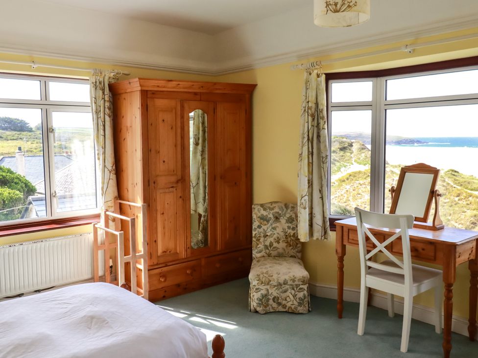 A bedroom with a wardrobe and desk at Chy-an-Lowena Crantock