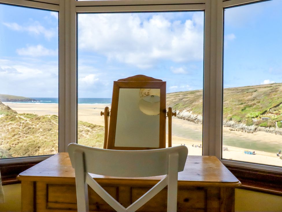 A room with a desk and a mirror looking out at the beach at Chy-an-Lowena, Crantock