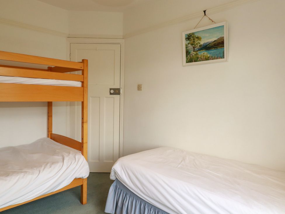 A bedroom with a bunk bed and a single bed at Chy-an-Lowena in Crantock