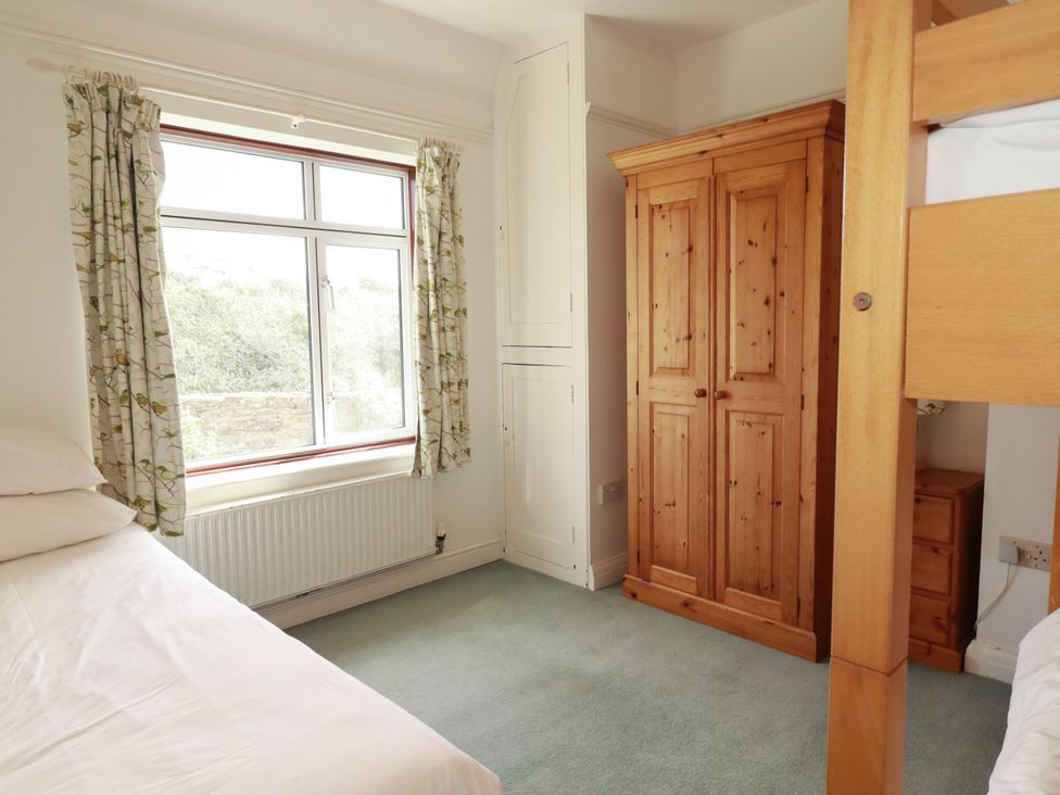 A bedroom with a bed and wardrobe at Chy-an-Lowena in Crantock