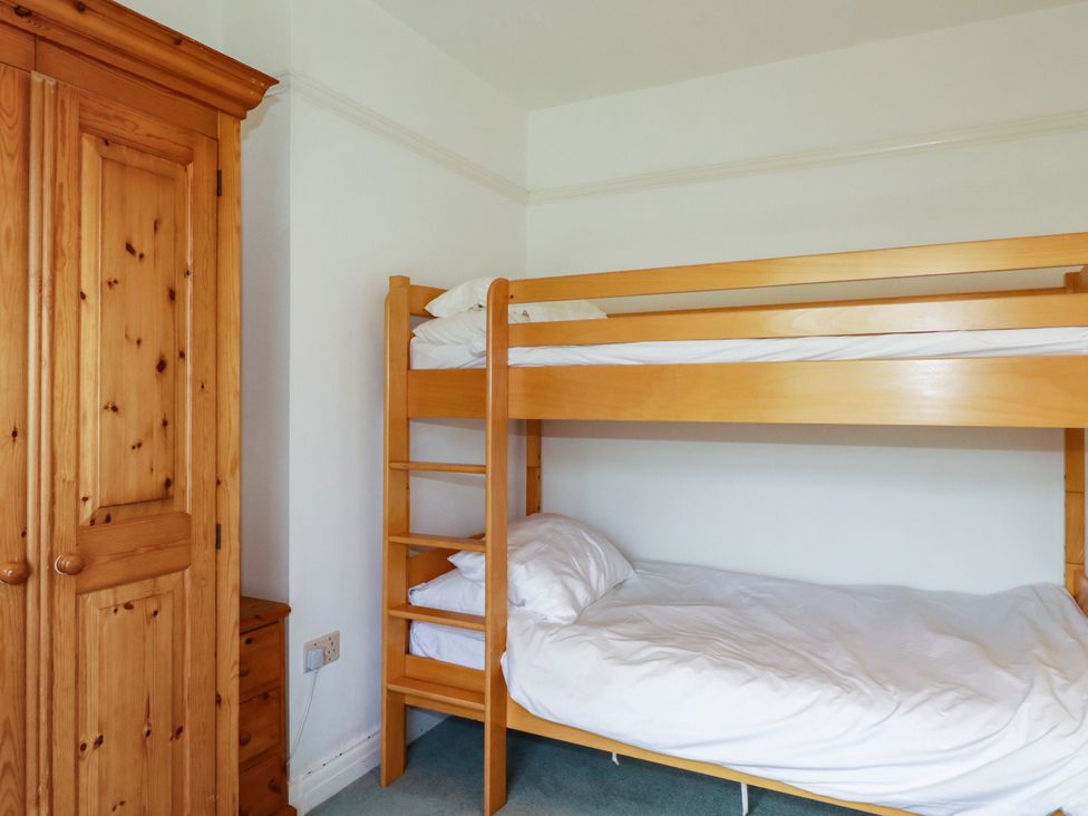 A bedroom with a bunk bed and wardrobe at Chy-an-Lowena in Crantock
