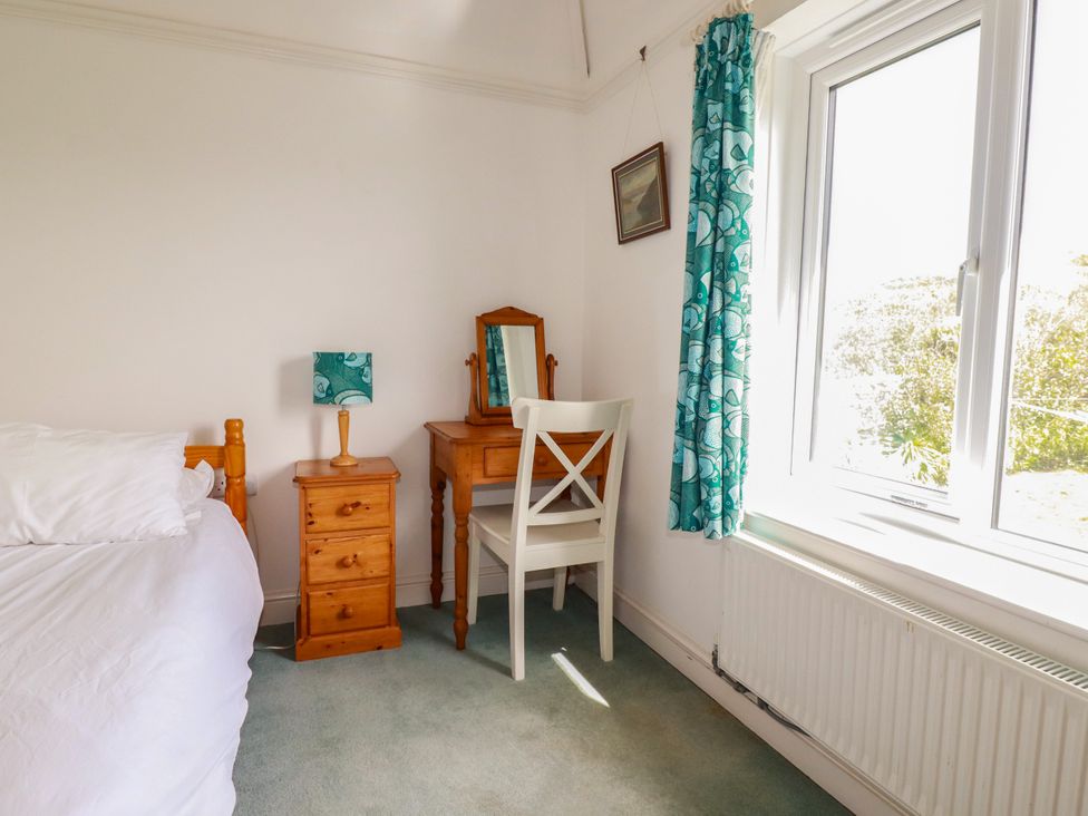 A bedroom with a bed and vanity table at Chy-an-Lowena in Crantock