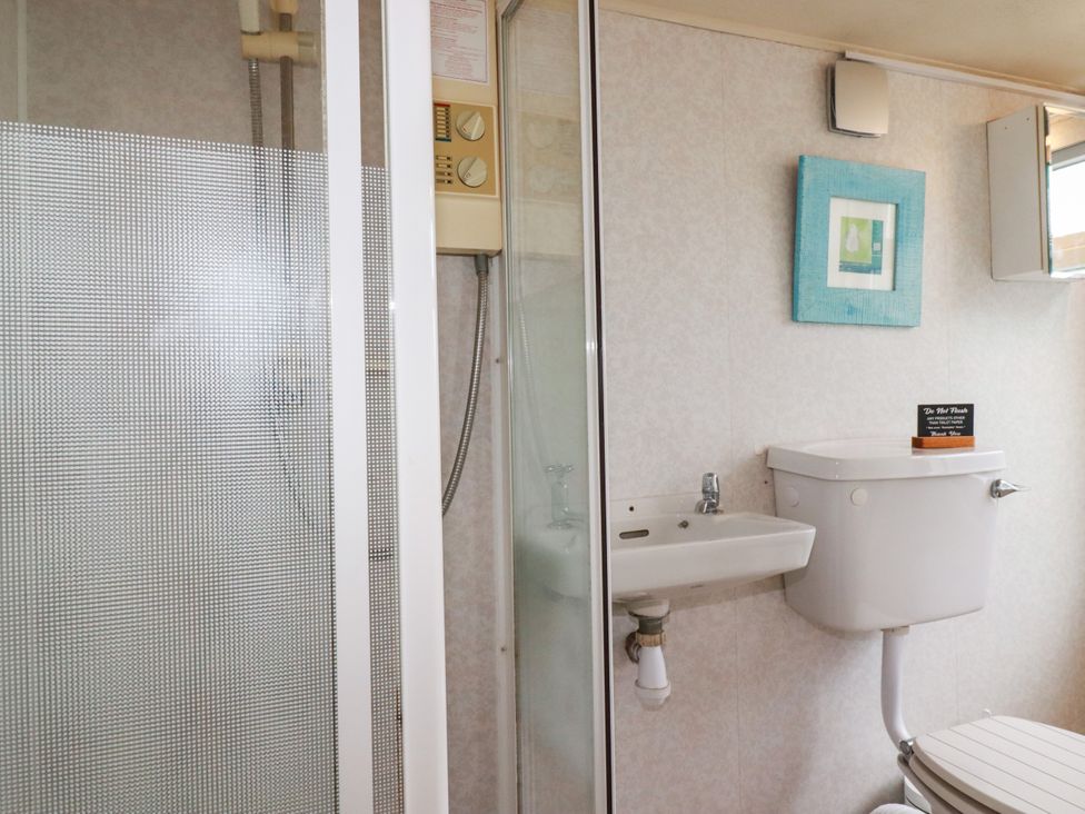 A bathroom with a shower, sink, and toilet at Chy-an-Lowena in Crantock