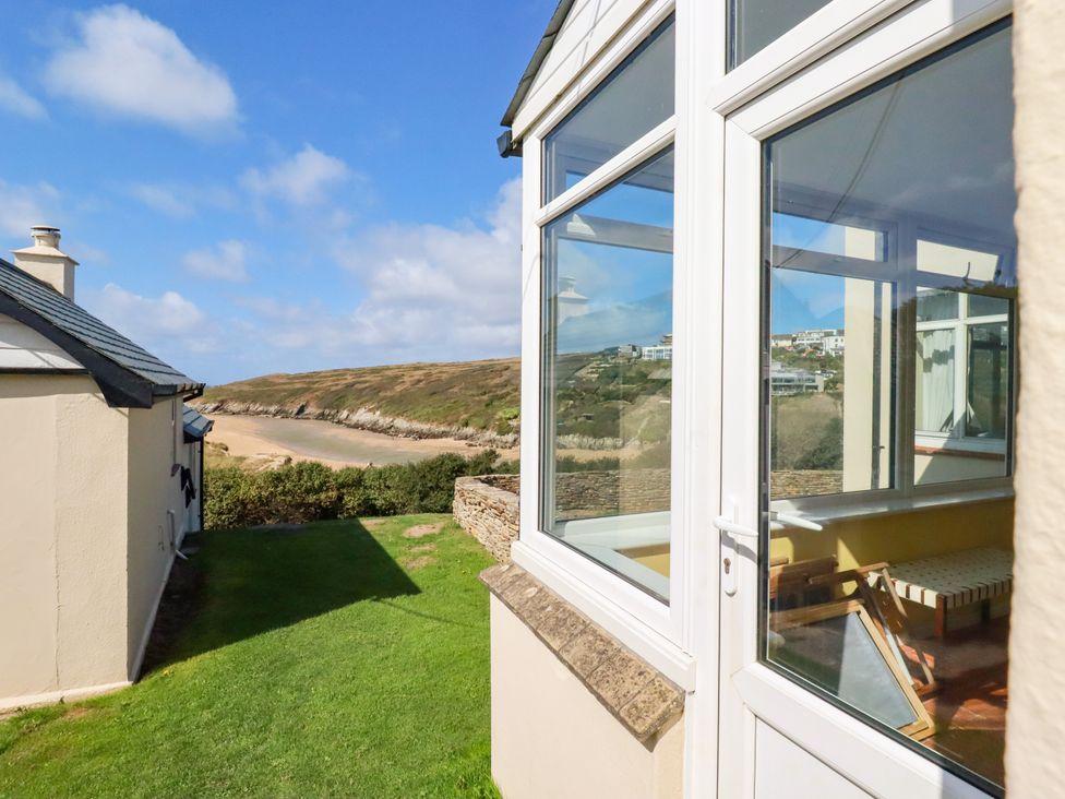 A view of the garden with a house and sea at Chy-an-Lowena in Crantock