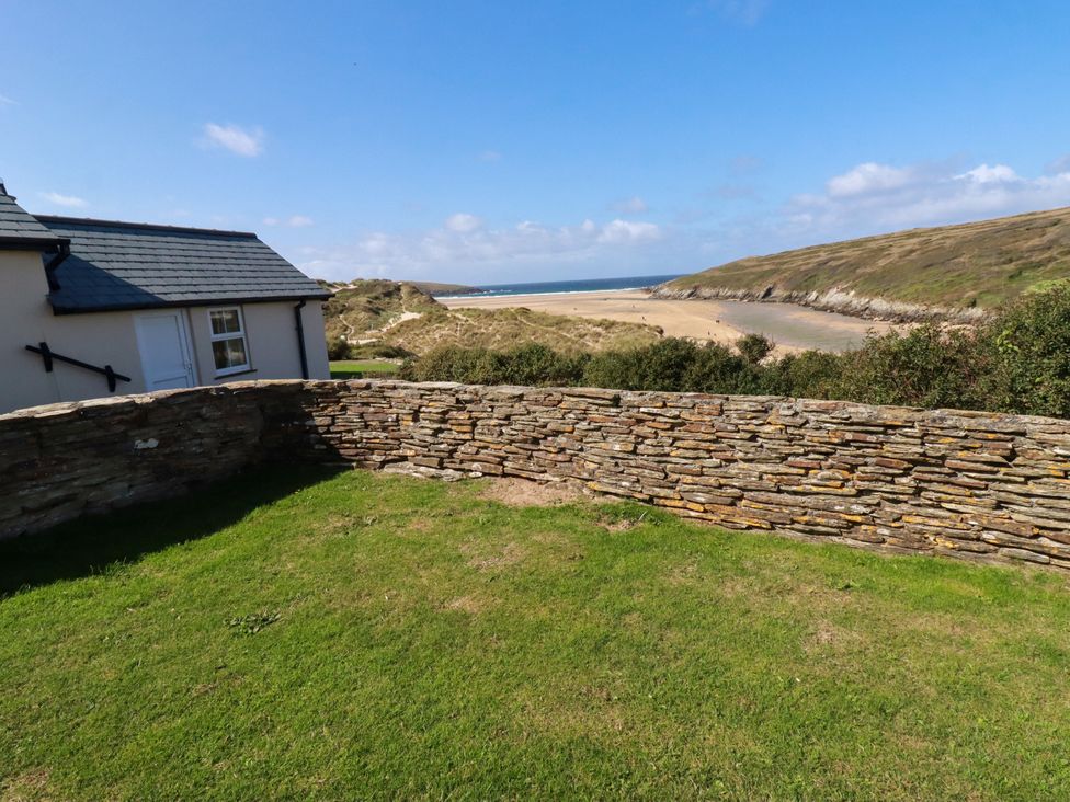 A view of a beach from a stone wall at Chy-an-Lowena in Crantock