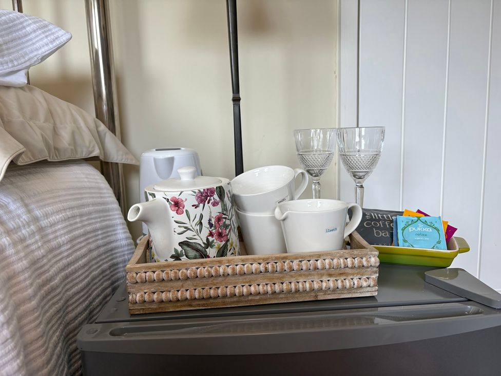 A tray with teapot and cups on a bedside table at Hafan y Tyddyn in Newport, Pembrokeshire