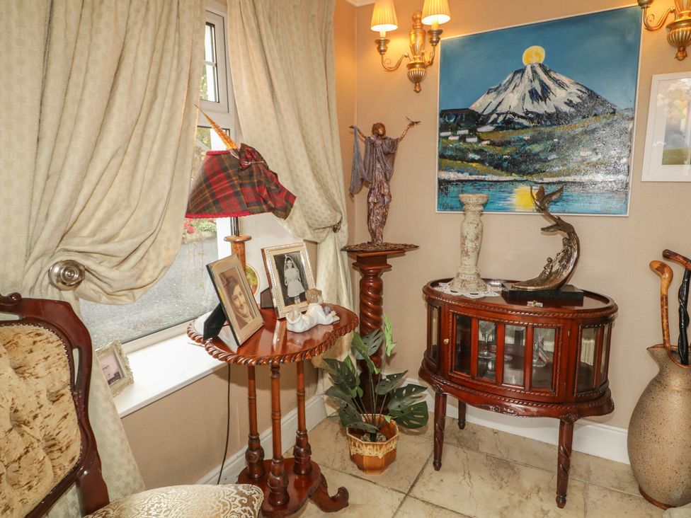 An entryway with a lamp and table displaying pictures at Bruckless Rest Fine Country Dining B&B Bruckless