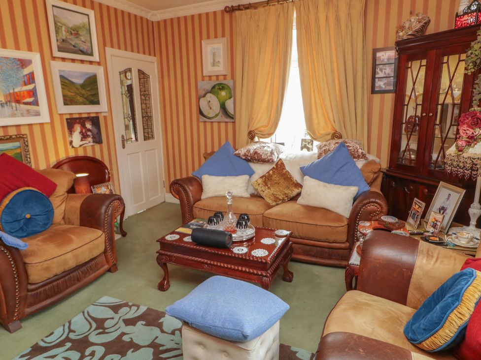 A living room with sofas, a coffee table, and paintings at Bruckless Rest Fine Country Dining B&B, Bruckless