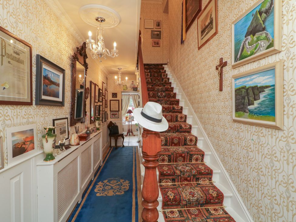 A hallway with a staircase and wall art at Bruckless Rest Fine Country Dining B&B Bruckless