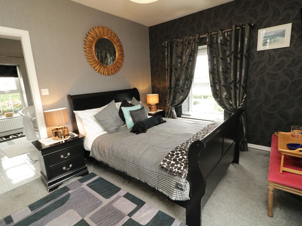 A bedroom with a bed and mirror at Bruckless Rest Fine Country Dining B&B Bruckless
