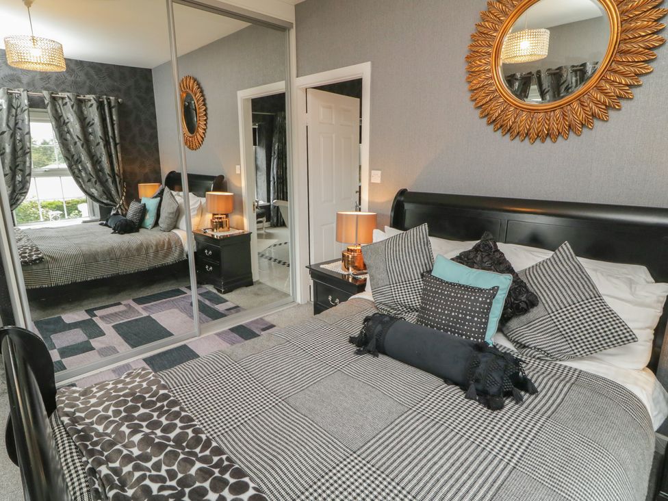 A bedroom with a bed and mirror at Bruckless Rest Fine Country Dining B&B, Bruckless