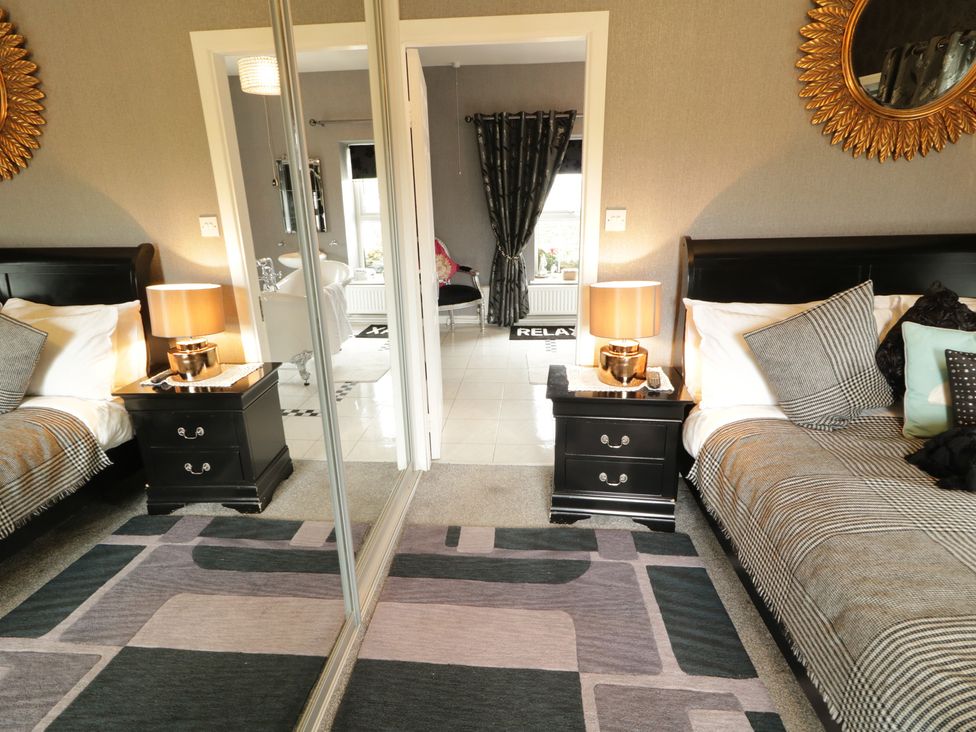 A bedroom with two beds and a view of a bathroom at Bruckless Rest Fine Country Dining B&B Bruckless