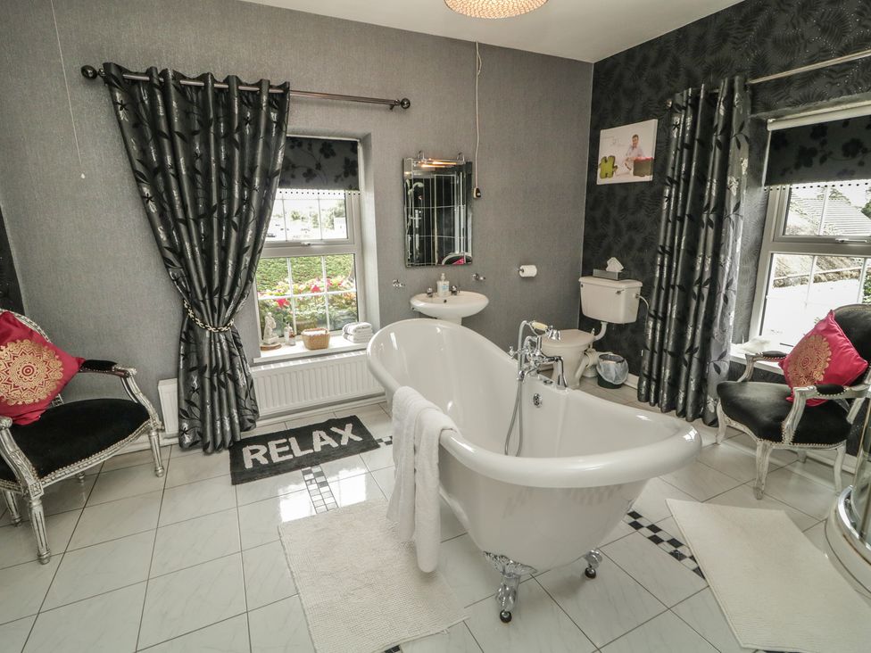 A bathroom with a bathtub and toilet at Bruckless Rest Fine Country Dining B&B in Bruckless