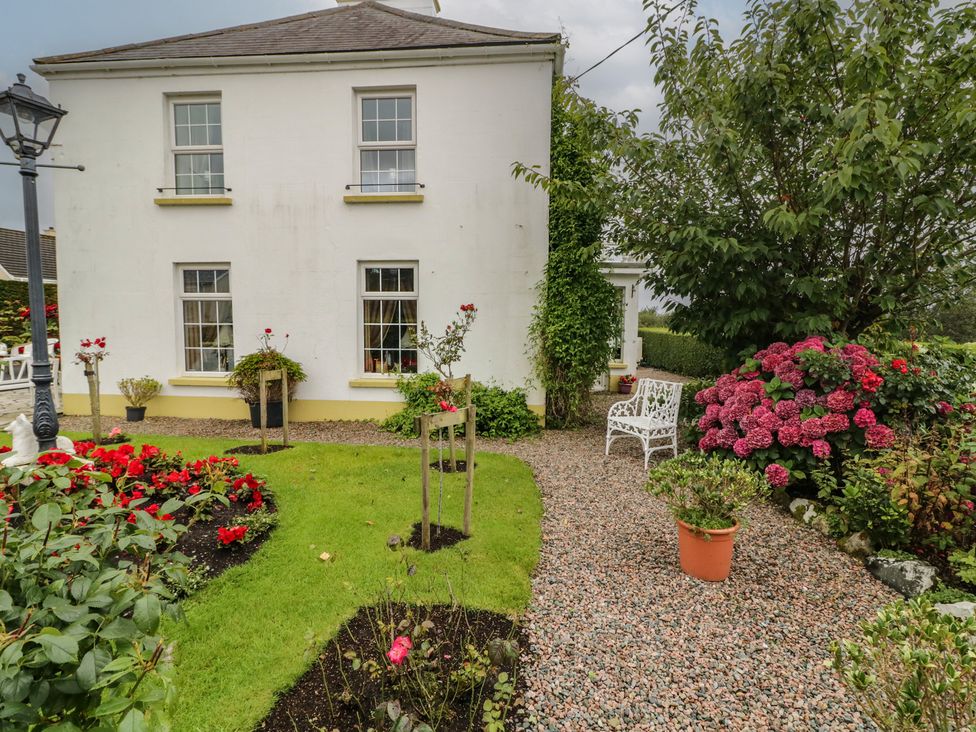 A garden with flowers and a bench at Bruckless Rest Fine Country Dining B&B in Bruckless
