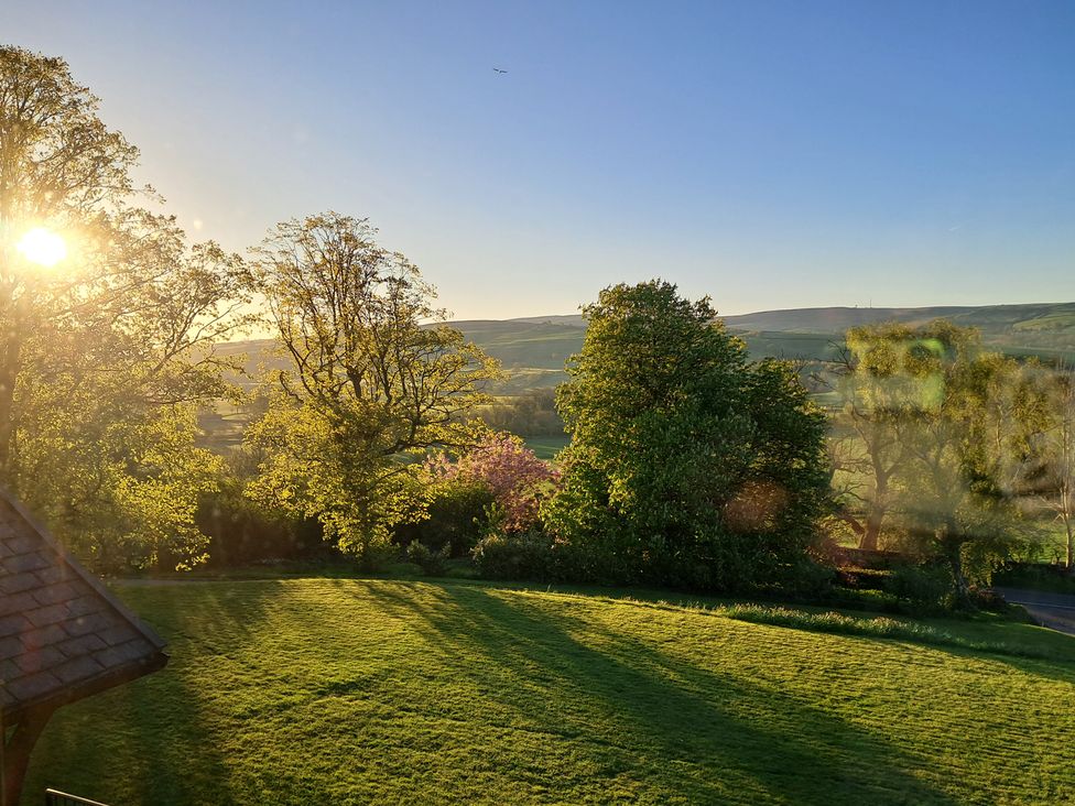 A view of trees and a grassy area with hills in the background at Castleys Mount in Skipton