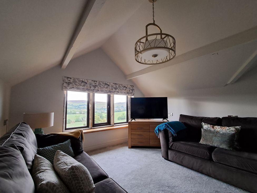 A living room with a sofa and television at Castleys Mount in Skipton