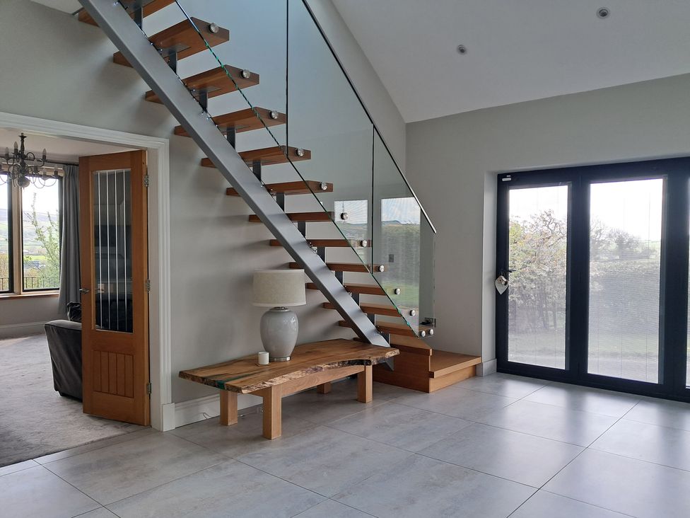A hallway with a staircase and a table at Castleys Mount Skipton